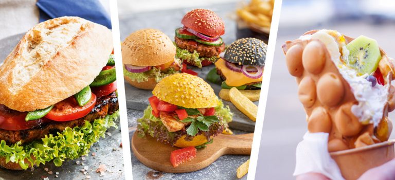 Street Food Festival Sandwich mit frischen Tomaten, Bohnen, Salat und Beef-Patty belegt neben bunten Burgern und einer mit Früchten gefüllten Bubblewaffle